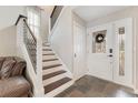 Inviting foyer featuring a staircase with metal railings and dark wood steps, with slate flooring at 5276 Rocking Horse Pl, Oviedo, FL 32765