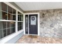 A welcoming front entrance with stone accents, a decorative wreath, and stylish lighting at 5276 Rocking Horse Pl, Oviedo, FL 32765