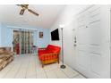 The living room with white tile floor, a ceiling fan, and a sliding glass doors leading to a porch at 5291 Images Cir # 302, Kissimmee, FL 34746