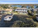 Aerial view of a waterfront home with a private pool and boat dock on a serene lake at 9138 Bay Point Dr, Orlando, FL 32819