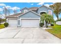 Charming two-story house with a three-car garage, a large driveway, and manicured landscaping at 105 Norris Pl, Casselberry, FL 32707