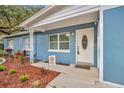 Inviting front porch with a white door, welcome mat, and colorful plants at 1416 E 20Th St, Sanford, FL 32771