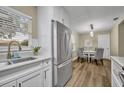 Kitchen featuring stainless steel refrigerator, white cabinetry, and a view of the dining area at 1416 E 20Th St, Sanford, FL 32771