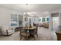 Bright dining area featuring a round wooden table, chandelier, and large windows at 14554 Black Cherry Trl, Winter Garden, FL 34787