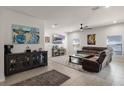 Spacious living room featuring tile floors, a ceiling fan, and a plush brown sectional sofa at 14554 Black Cherry Trl, Winter Garden, FL 34787