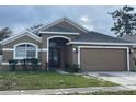 Charming single-story home featuring an attached two-car garage and neutral-toned exterior at 14954 Lady Victoria Blvd, Orlando, FL 32826