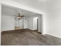 Spacious living room featuring neutral carpet, white trim and a view of the tile floor in the adjacent room at 1622 Dolphin Dr, St Cloud, FL 34771