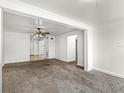 Open living area with plush carpeting and neutral paint, with a view to the kitchen at 1622 Dolphin Dr, St Cloud, FL 34771