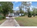 Inviting home with a long driveway, gray exterior, and mature trees at 200 Avenue C, Chuluota, FL 32766