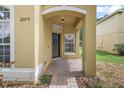 Inviting covered front porch with a black front door and manicured landscaping around the entrance at 2073 Home Again Rd, Apopka, FL 32712