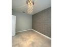 Stylish bedroom showcasing a geometric accent wall, contemporary light fixture, and tile flooring at 2475 Verde View Dr, Apopka, FL 32703