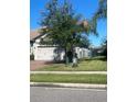 Well-manicured lawn and mature trees accent this attractive home with a two-car garage at 2475 Verde View Dr, Apopka, FL 32703