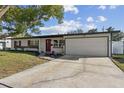 Charming single-story home features a red front door, attached garage and well-maintained front lawn at 3632 E Kaley Ave, Orlando, FL 32812