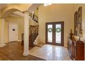 Elegant foyer with soaring ceilings, decorative iron doors, and beautiful travertine tile at 5719 Emerson Pointe Way, Orlando, FL 32819