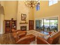 Spacious living room with fireplace, high ceilings, and sliding glass doors leading to a pool at 5719 Emerson Pointe Way, Orlando, FL 32819