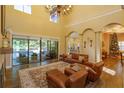 Bright living room with view to the pool area, tall ceilings, and elegant fireplace at 5719 Emerson Pointe Way, Orlando, FL 32819