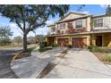 Inviting two-story townhome with a spacious driveway and well-manicured front yard at 701 Fortanini Cir, Ocoee, FL 34761