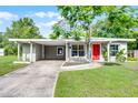 Inviting single-story home featuring a carport, well-maintained lawn, and vibrant landscaping at 704 Baywood Dr, Sanford, FL 32773