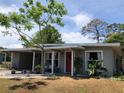 Charming single story home featuring a front yard, a red door with a wreath, and a covered carport at 704 Baywood Dr, Sanford, FL 32773