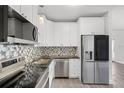Modern kitchen featuring stainless steel appliances, granite countertops, and stylish backsplash at 704 Baywood Dr, Sanford, FL 32773