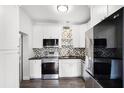 Well-lit kitchen equipped with stainless appliances, white cabinetry, and mosaic backsplash at 704 Baywood Dr, Sanford, FL 32773