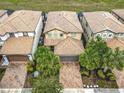 Overhead shot showcasing a home's tile roof, brick driveway, landscaping, and proximity to neighboring houses at 8941 Rhodes St, Kissimmee, FL 34747