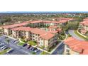 An elevated view showing the community's terracotta roofs, landscaping, parking, and surrounding roads at 912 Charo Pkwy # 214, Davenport, FL 33897