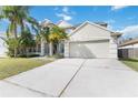 Bright two-story home with palm trees, two-car garage, and a long driveway leading up to the entrance at 965 Rosinia Ct, Orlando, FL 32828