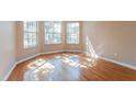 Sun-drenched living room featuring gleaming hardwood floors and large windows at 1019 Royal Oaks Dr, Apopka, FL 32703