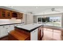 Bright kitchen showcasing a wooden island with a sink and a large window at 12002 Mckinnon Rd, Windermere, FL 34786