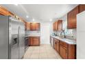 Well-lit kitchen featuring stainless steel refrigerator and appliances, granite countertops, and wood cabinetry at 12853 Maryland Woods Ct, Orlando, FL 32824