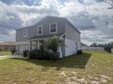 Charming two-story home with gray siding, manicured lawn, and inviting front porch at 137 Willow Dr, Kissimmee, FL 34759