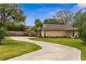View of home with a winding driveway and lush green lawn, surrounded by mature trees at 1581 Monica Joy Cir, Longwood, FL 32779