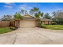 View of two car garage with a concrete driveway and mature trees, plus small garden along side at 1581 Monica Joy Cir, Longwood, FL 32779