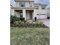 Inviting two-story home featuring a welcoming porch and lush landscaping at 17792 Adrift Rd, Winter Garden, FL 34787