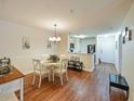 Bright dining area with a white table set for four, wood floors, and an open view to the kitchen at 1910 Summer Club Dr # 108, Oviedo, FL 32765