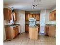 Well-lit kitchen with central island, stainless appliances, tile floors and granite countertops at 2143 Tealwood Cir, Tavares, FL 32778