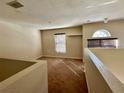 Cozy loft area with carpet flooring and natural light from the window at 2143 Tealwood Cir, Tavares, FL 32778