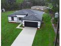 Aerial view of a modern home with a large driveway and well-maintained lawn at 2252 Sw 168Th Loop, Ocala, FL 34473