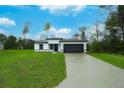 Modern home featuring a spacious lawn, two-car garage, and contemporary black and white design at 2252 Sw 168Th Loop, Ocala, FL 34473
