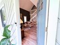 Open front door view of a cozy living room with wood floors and a staircase leading to the upper level at 25704 Aberdovey Ave, Sorrento, FL 32776