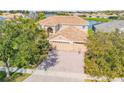 Elegant exterior with tile roof, three-car garage, and brick paved driveway at 2631 Captains Ct, Kissimmee, FL 34746