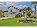 Elegant home featuring a three-car garage, lush landscaping, and a circular flower bed enhancing curb appeal at 3180 Pawleys N Loop, St Cloud, FL 34769