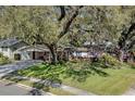 Charming single-story home with lush landscaping and a large mature tree in the front yard at 3407 Pershing Ave, Orlando, FL 32812
