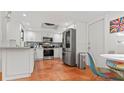 Modern kitchen with stainless steel appliances, white cabinets, and brick-tile flooring at 5646 Spring Run Ave, Orlando, FL 32819