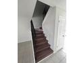View of carpeted staircase featuring decorative wrought iron banister and freshly painted walls at 6046 Village Cir # 6046, Orlando, FL 32822