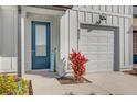 Close up of the house entrance, featuring a modern blue front door, landscaping, and attached garage at 925 Conch Rd, Davenport, FL 33896