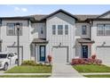 Charming two-story townhome with a front entry garage, blue door, and professionally landscaped yard at 925 Conch Rd, Davenport, FL 33896