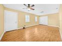 Spacious living room featuring wood floors, ceiling fan, and natural light from windows at 109 Mcquigg Ave, Orlando, FL 32805