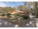 Well-kept front yard showcases this brick home with mature landscaping and a lengthy driveway at 1101 N Valencia Ave, Howey In The Hills, FL 34737